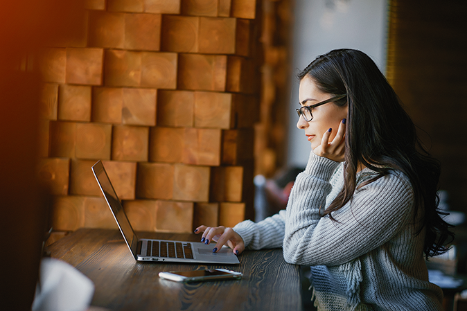 Young woman concentrating on laptop at table