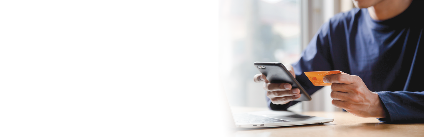 Man holding his phone and a credit card to make an online payment